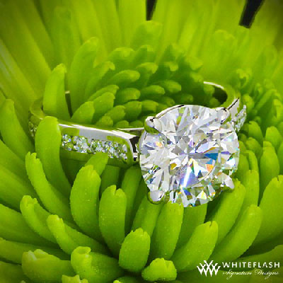 4 prong round cut diamond engagement ring on a green grass