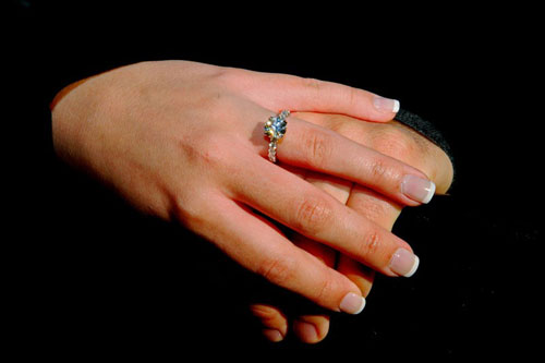 gold solitaire ring on a hand