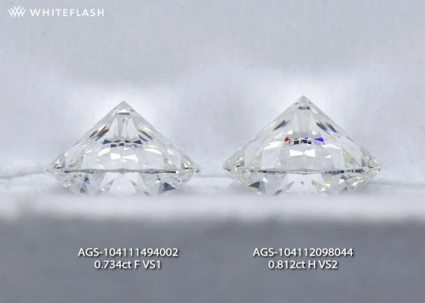 Side-by-side comparison of two round brilliant diamonds viewed from the pavilion. The left diamond (0.734ct F VS1) appears whiter, while the right diamond (0.812ct H VS2) has a slight warmth, demonstrating differences in color grading.