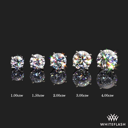 Five pairs of round brilliant diamond stud earrings displayed in ascending size order from 1.00ctw to 4.00ctw on a black reflective surface, showcasing sparkle and size differences.