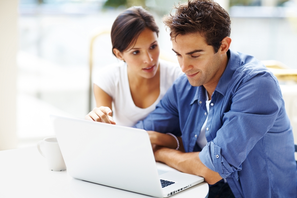 A couple searching the internet on a laptop
